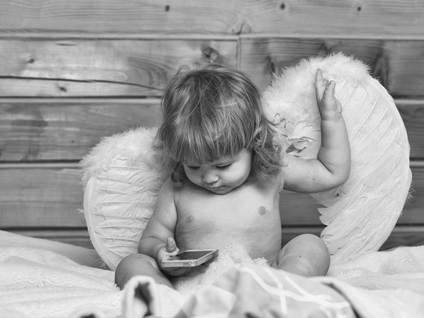 Angel boy with phone - Foto, afbeelding