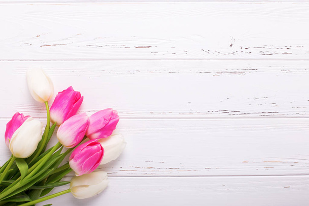 Bright pink and white tulips flowers on vintage white wooden background. Place for text.  - Fotografie, Obrázek