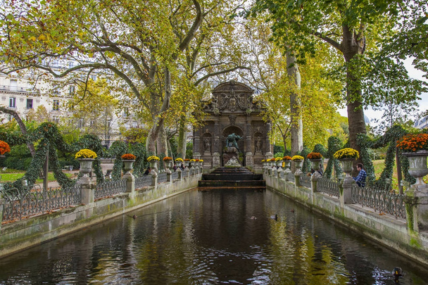 PARIS, FRANCE, on October 30, 2017. Autumn city landscape. The turned yellow trees picturesquely frame Medici's fountain in the Luxembourg garden - Foto, afbeelding
