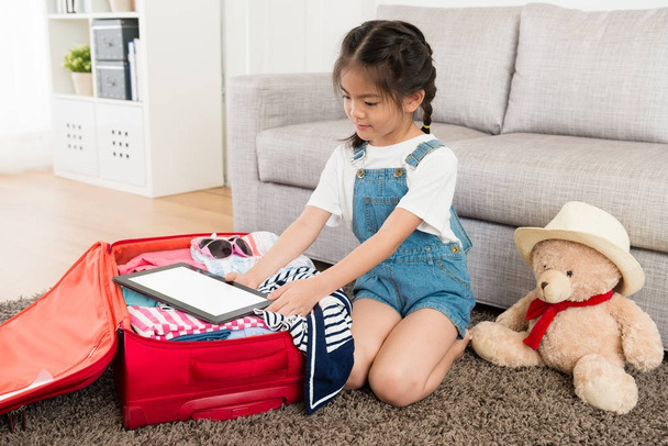 гарна маленька дівчинка упаковка особистого дорожнього багажу
 - Фото, зображення