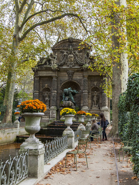 PARIS, FRANCE, on October 30, 2017. Autumn city landscape. The turned yellow trees picturesquely frame Medici's fountain in the Luxembourg garden - Foto, immagini