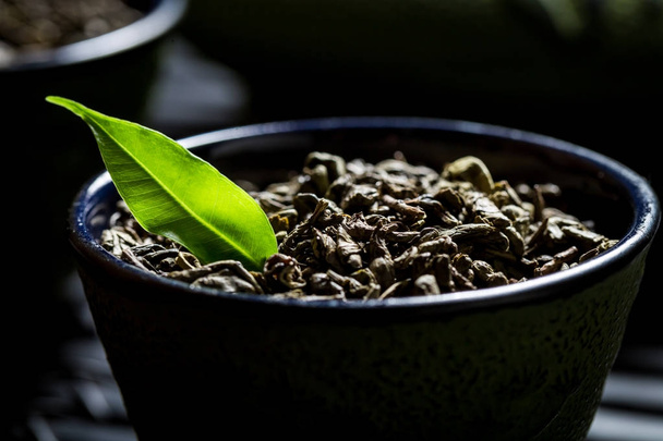 Closeup of grains green tea on black teacup - Zdjęcie, obraz