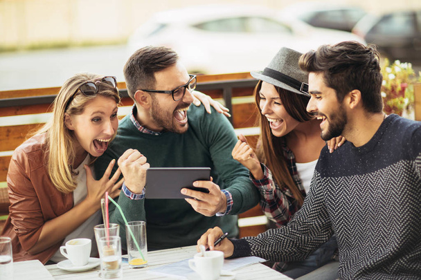 ryhmä onnellisia nuoria kahvilassa hauskaa yhdessä ja käyttämällä tablet-tietokone
 - Valokuva, kuva