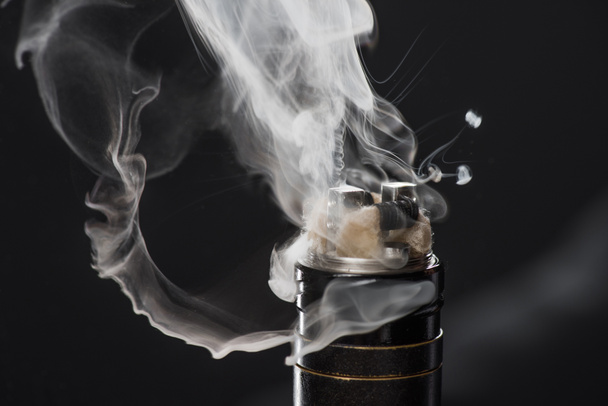 Aktywowanie elektroniczny papieros z chmury dymu na ciemnym tle - Zdjęcie, obraz