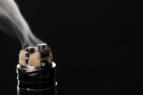Activating electronic cigarette isolated on black background - 写真・画像