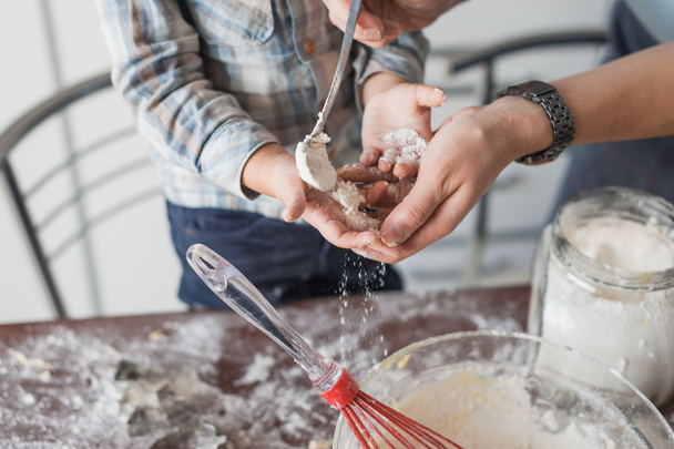 cropped shot of mother putting flour on child hands to prepare dough - Фото, зображення