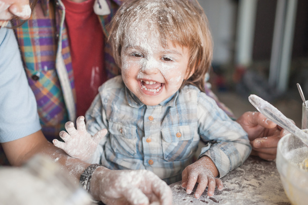 笑う少年は両親と一緒に料理しながら小麦粉で覆われて - 写真・画像