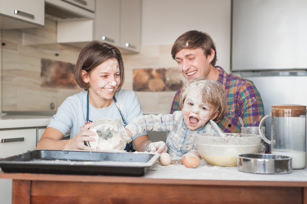 Junge Familie kocht in Küche gemeinsam mit Mehl - Foto, Bild