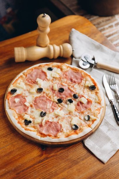 Kellemes pizza a fa vágódeszka evőeszközök a vászon szalvéta  - Fotó, kép