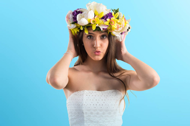 Girl with crown of flowers covering her ears - Foto, Imagen