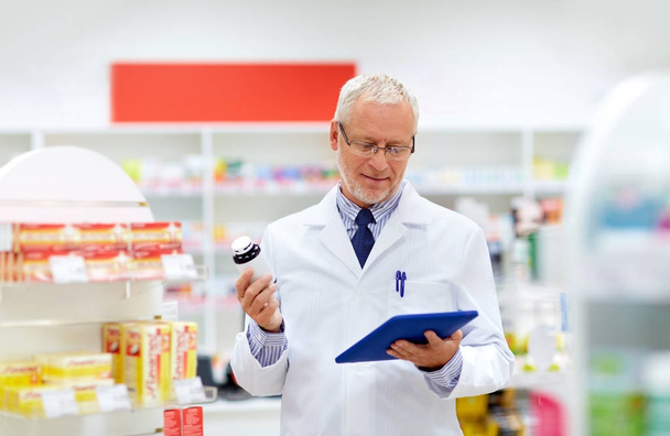 senior with tablet pc at pharmacy - Фото, изображение