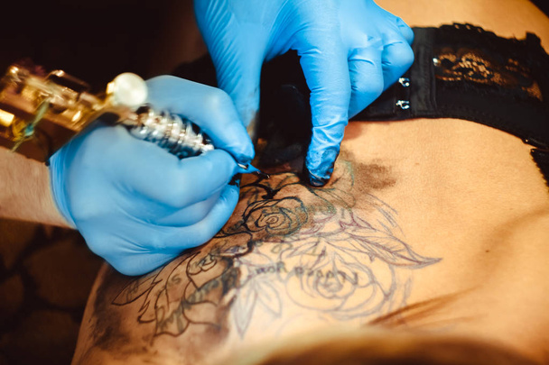 mester tetoválás a nő a hátán - Fotó, kép