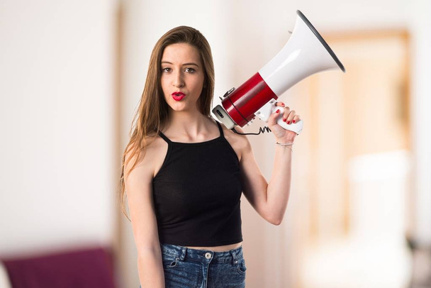Young girl shouting by megaphone - Фото, изображение
