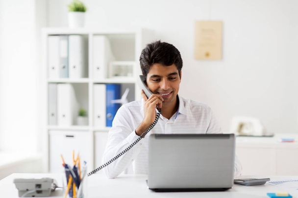 happy businessman calling on desk phone at office - Photo, Image