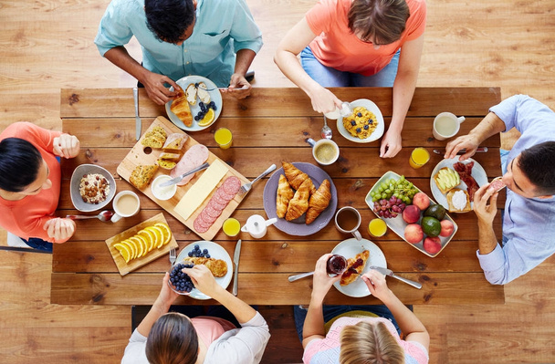group of people having breakfast at table - Фото, изображение
