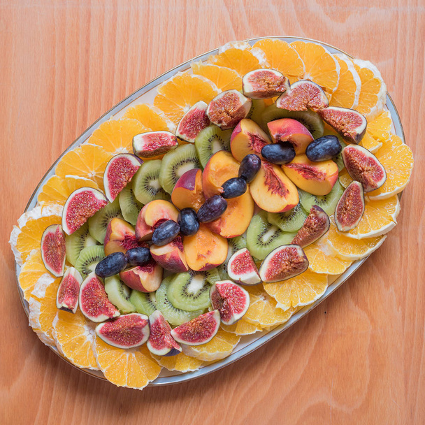 plate with arranged fruits on wooden background - Foto, Bild