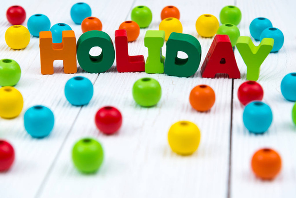 Holiday colorful wooden text on white wooden desk with Christmas - 写真・画像
