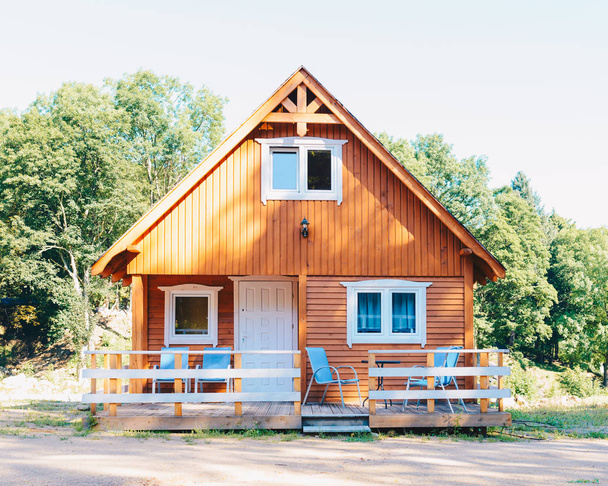 Pequeña casa de madera en el estilo noruego con una terraza
 - Foto, Imagen
