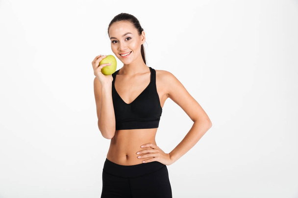 Portrait of a healthy asian fitness woman holding apple - Foto, immagini