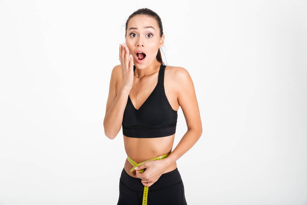 Portrait of a shocked asian fitness woman - Photo, Image
