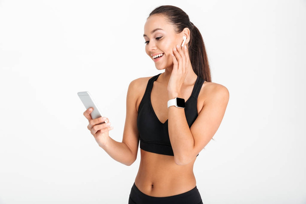 Portrait of a smiling asian fitness woman listening to music - Foto, Imagem