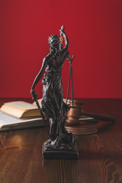 aufgeschlagene juristische Bücher mit Dame Gerechtigkeitsstatue auf Holztisch, Gesetzeskonzept - Foto, Bild