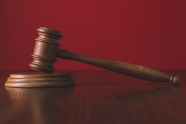 martelo julgamentos sobre mesa de madeira na frente de fundo vermelho, conceito de lei
 - Foto, Imagem
