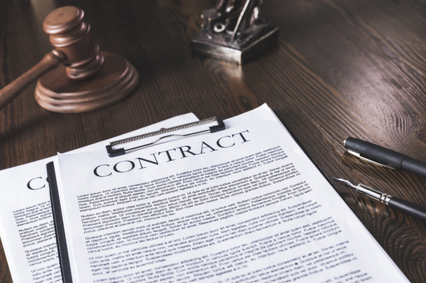 juridical contract on wooden table with pen and hammer, law concept - Photo, Image