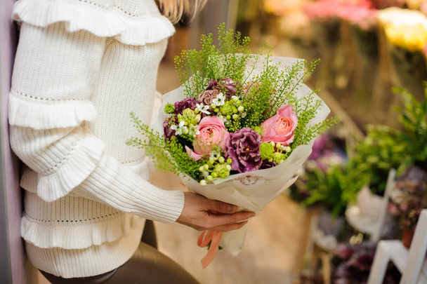Woman dressed in a white sweater holding a pretty valentine bouquet - Фото, зображення