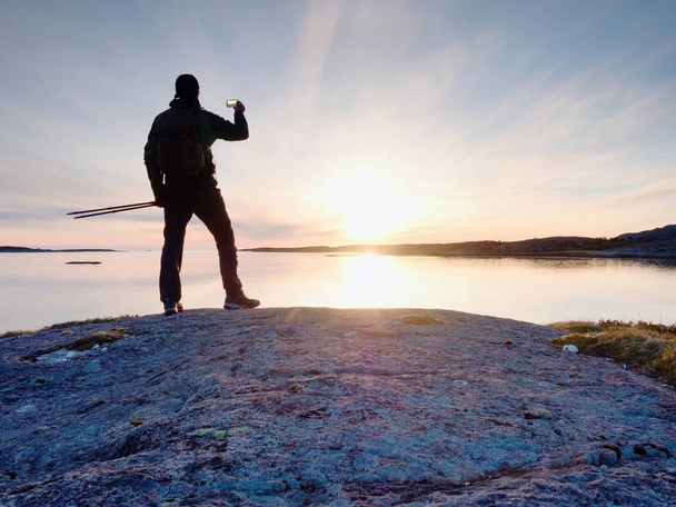 Turystyczna facet fotografowania niesamowity krajobraz morze na cyfrowy aparat fotograficzny telefon komórkowy. - Zdjęcie, obraz