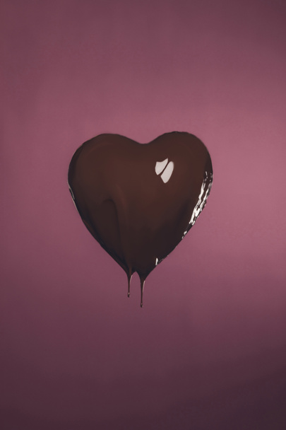 heart shaped candy with liquid chocolate isolated on pink - 写真・画像