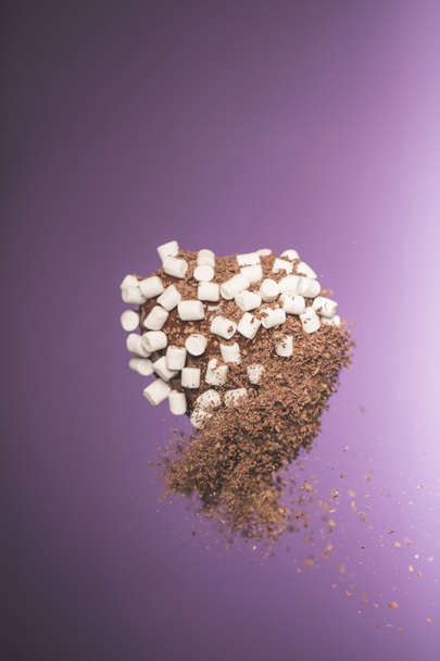 шоколадные конфеты в форме сердца с зефиром и крошечный шоколад изолированы на фиолетовый
 - Фото, изображение