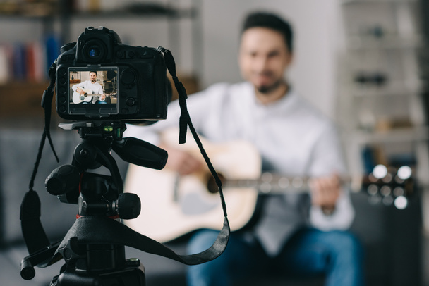 music blogger playing acoustic guitar in front of camera - Foto, Bild