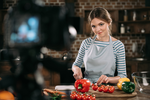 young food blogger cutting cherry tomatoes   - Фото, зображення
