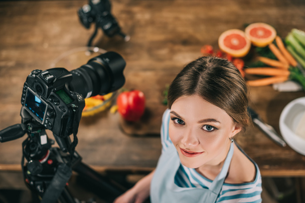 カメラを見て魅力的な食品のブロガーのオーバー ヘッド ビュー - 写真・画像