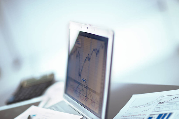 Businessman analyzing investment charts with laptop. - Zdjęcie, obraz
