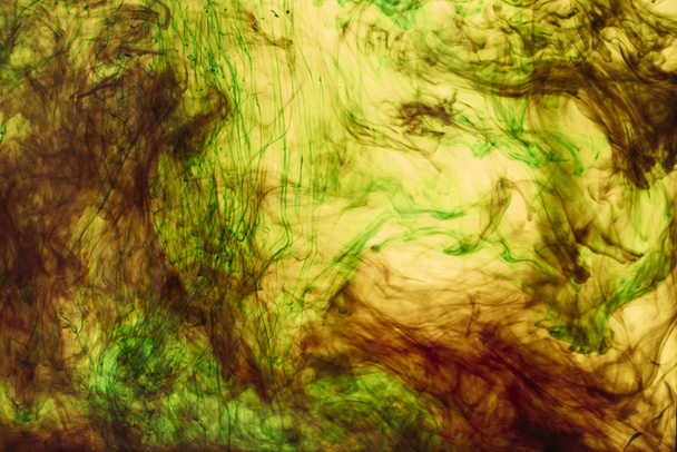 full frame van gele en groene verf spatten en dwarrelt - Foto, afbeelding