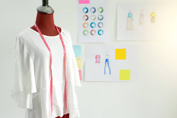 Modedesigner arbeiten im Atelier mit Grafik- und Schneiderwerkzeug - Foto, Bild