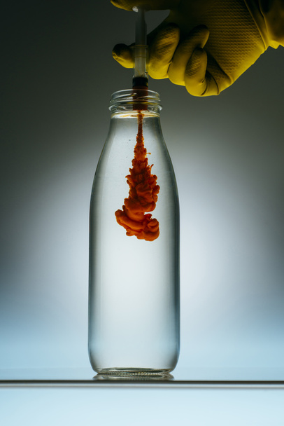 vista recortada de la persona que vierte sangre de la jeringa en el frasco con agua
 - Foto, Imagen