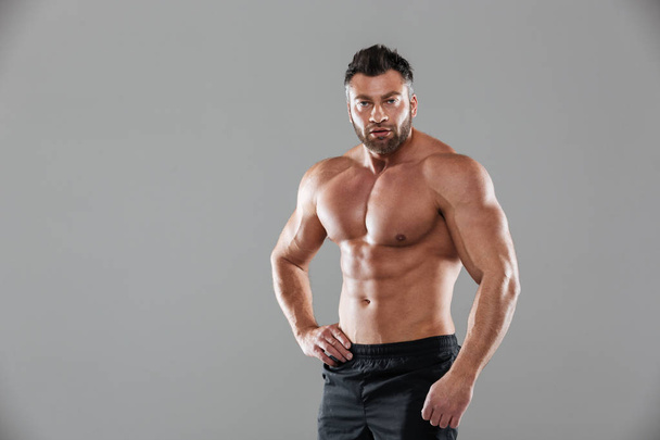 Portret van een gespierde sterke shirtless mannelijke bodybuilder - Foto, afbeelding