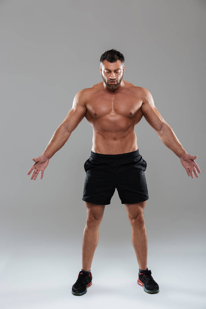 Full length portrait of a confident strong shirtless male bodybuilder - Foto, Imagem