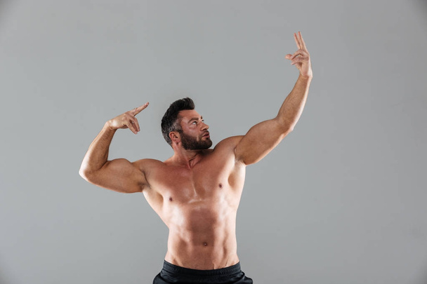 Portrait of a muscular strong shirtless male bodybuilder - Foto, Bild