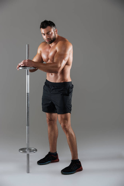 Full length portrait of a muscular serious shirtless male bodybuilder - Fotografie, Obrázek
