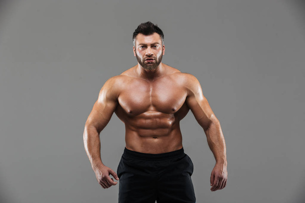 Portrait of a confident strong shirtless male bodybuilder - Fotó, kép