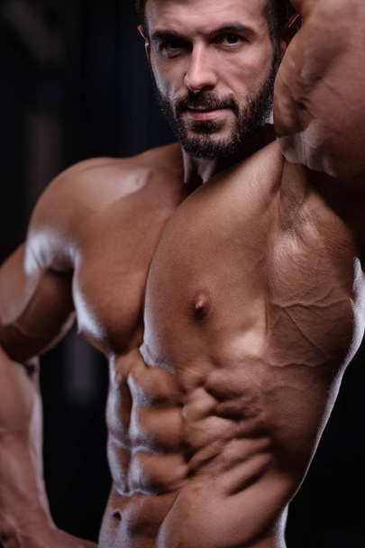 sexy strong bodybuilder athletic men pumping up muscles with dum - Foto, Imagen
