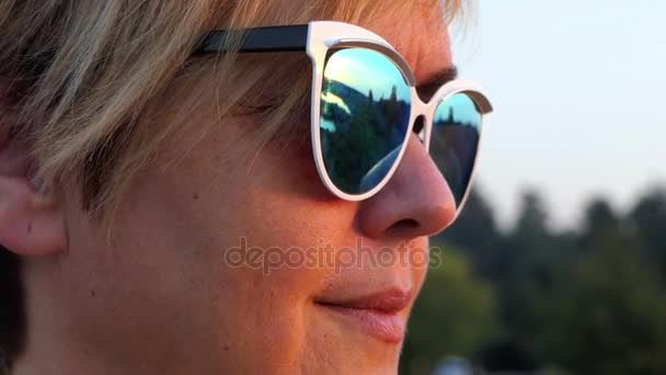 Krásný středního věku žena s úsměvem v sluneční brýle v pomalém pohybu. - Záběry, video