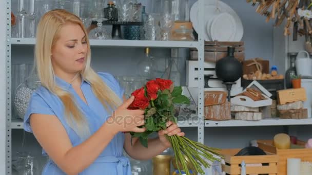 sonriente florista mujer haciendo ramo en floristería
 - Imágenes, Vídeo