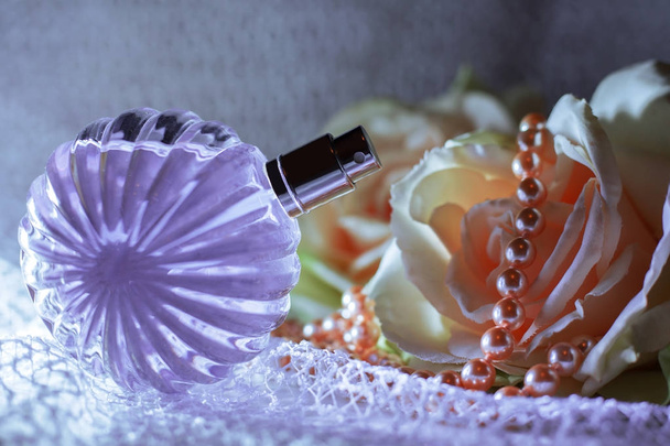 Parfumfles met bloemen en parels  - Foto, afbeelding