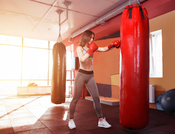 Young women boxing, hitting the boxing bag - 写真・画像