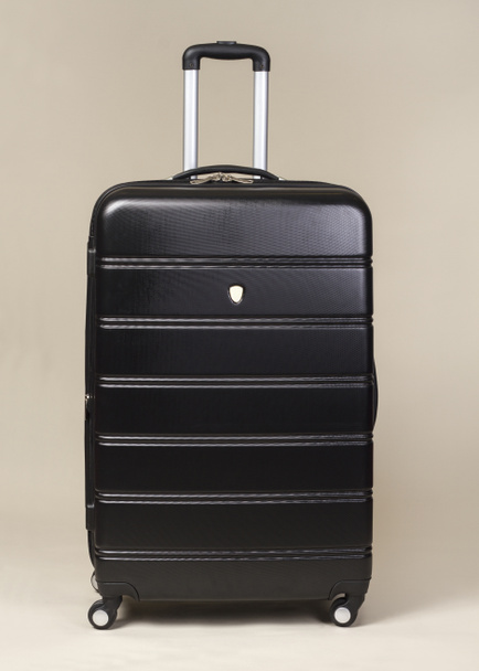 Βαλίτσα τσάντα μαύρη τρόλεϊ που απομονώνονται σε μπεζ φόντο - Φωτογραφία, εικόνα
